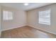 Neutral-toned bedroom with refinished floors and natural light from the two windows at 80 Crystal River Dr, Riverdale, GA 30274