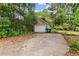 Single car brick garage with basketball hoop and adjacent parking space in wooded backyard at 5128 Lavista Rd, Tucker, GA 30084