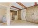 Spacious sunroom with stone accent wall, wooden beams, and access to a bathroom and other rooms at 5128 Lavista Rd, Tucker, GA 30084