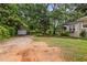 Wide view of wooded backyard including single car garage and side view of house at 5128 Lavista Rd, Tucker, GA 30084