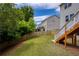Scenic backyard with a grassy lawn, wooden fence, and lush trees in the background at 6510 Boulder Rdg, Cumming, GA 30028