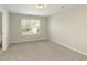 This well-lit bedroom features plush carpeting, neutral paint, and a bright window at 6510 Boulder Rdg, Cumming, GA 30028