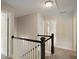 Upstairs hallway featuring modern carpet flooring with black and white staircase at 6510 Boulder Rdg, Cumming, GA 30028