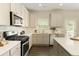 Well-lit kitchen with stainless steel appliances, white cabinets, and a white tile backsplash at 6510 Boulder Rdg, Cumming, GA 30028