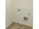 Compact laundry room with wood-look flooring and utility connections at 6510 Boulder Rdg, Cumming, GA 30028
