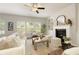 Cozy living room with a fireplace, built-in shelving, neutral furniture, and plenty of natural light at 6510 Boulder Rdg, Cumming, GA 30028