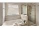 Bright bathroom with soaking tub, shower, and window allowing natural light at 6510 Boulder Rdg, Cumming, GA 30028