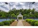 A well-maintained tennis court with a central covered seating area surrounded by lush landscaping at 6510 Boulder Rdg, Cumming, GA 30028