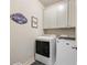 Well-lit laundry room with front load washer, dryer, storage cabinets, and a quirky laundry room sign at 2506 Skyland Ne Dr # 17, Atlanta, GA 30319