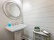 Charming powder room features shiplap walls, pedestal sink, and decorative round mirror at 2506 Skyland Ne Dr # 17, Atlanta, GA 30319