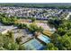 A scenic aerial view of a community featuring a pond, pool, tennis courts, and lush greenery at 5909 Rue Chase Way, Tucker, GA 30084