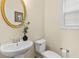 Powder room features a pedestal sink, classic mirror, and natural light from a nearby window at 5909 Rue Chase Way, Tucker, GA 30084