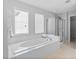 Large soaking tub and glass shower next to bright windows in a bathroom at 5909 Rue Chase Way, Tucker, GA 30084