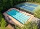 An outdoor community pool is surrounded by lounge chairs and features a tennis court in the background at 5909 Rue Chase Way, Tucker, GA 30084