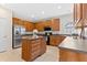 Well-lit kitchen boasts stainless steel appliances, wood cabinetry, and center island with breakfast bar at 5909 Rue Chase Way, Tucker, GA 30084