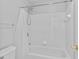 All-white shower and tub combination with tile surround and chrome fixtures at 5909 Rue Chase Way, Tucker, GA 30084
