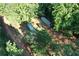Aerial view of the treed property featuring shipping containers and vehicle on site at 6675 Millwood Rd, Cumming, GA 30041