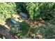 Aerial view of the treed property featuring shipping containers and vehicle on site at 6675 Millwood Rd, Cumming, GA 30041