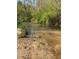 Creek flowing through a lush green landscape under a bright sky at 6675 Millwood Rd, Cumming, GA 30041