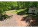 Small white outbuilding is surrounded by forest on a dirt drive at 6675 Millwood Rd, Cumming, GA 30041