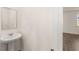 Modern bathroom features a pedestal sink and a view into another room at 1159 Blue Juniper Cir, Loganville, GA 30052