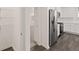 View from Pantry to kitchen with Stainless Steel Appliances, white cabinets and hardwood floors at 1159 Blue Juniper Cir, Loganville, GA 30052