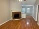 Open living room with brick fireplace, ceiling fan and hardwood floors at 233 Winterville Dr, Rockmart, GA 30153