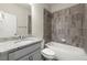 Well-lit bathroom features a granite countertop, white cabinets, and a tiled shower over the tub at 3483 Addilyn Ne Ct, Marietta, GA 30066