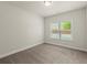 A carpeted bedroom with a window and neutral-colored walls at 3483 Addilyn Ne Ct, Marietta, GA 30066