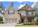 Inviting two-story home with a two-car garage, stone accents, and professionally landscaped front yard at 3483 Addilyn Ne Ct, Marietta, GA 30066