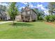 Traditional home featuring well-maintained lawn, mature trees, and attached two-car garage at 3483 Addilyn Ne Ct, Marietta, GA 30066