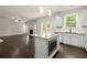 Open-concept kitchen with island, stainless steel appliances, and seamless flow into the living area with a fireplace at 3483 Addilyn Ne Ct, Marietta, GA 30066