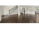 Spacious room featuring hardwood floors, staircase with iron railings, and open access to other spaces at 3483 Addilyn Ne Ct, Marietta, GA 30066