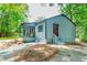 Charming exterior of a home featuring a covered porch, well-maintained yard, and a tranquil wooded backdrop at 391 Buchanan St, Dallas, GA 30157