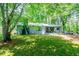 Serene exterior shot showcasing a home with covered porch, lush greenery, and mature trees creating a tranquil ambiance at 391 Buchanan St, Dallas, GA 30157
