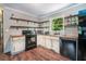 Functional kitchen with distressed cabinets, open shelving, and modern appliances, creating a rustic charm at 391 Buchanan St, Dallas, GA 30157