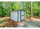 A backyard shed with a dark trim surrounded by trees and a gravel bed at 391 Buchanan St, Dallas, GA 30157