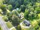 An aerial view showcases a property with dense tree cover and vehicle movement on the road at 14301 Veterans Memorial Highway, Villa Rica, GA 30180