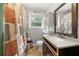 This bathroom includes shower with patterned curtain, vanity, commode, window and decorations at 14301 Veterans Memorial Highway, Villa Rica, GA 30180
