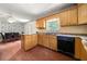 This kitchen features wooden cabinets, laminate countertops, and a black dishwasher at 14301 Veterans Memorial Highway, Villa Rica, GA 30180
