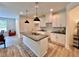 Modern kitchen with white cabinets, black countertops, stylish pendant lighting, and stainless steel sink at 1824 Emory Ln # 88, Conyers, GA 30013