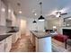 Well-lit kitchen with white cabinets, stylish pendant lights, and an open layout to the living area at 1824 Emory Ln # 88, Conyers, GA 30013