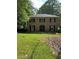 Traditional brick home featuring symmetrical design, well-kept lawn, and mature trees at 2315 Hudson Sw Dr, Lilburn, GA 30047