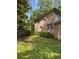 View of the side of a brick home, showcasing the lawn and simple landscaping at 2315 Hudson Sw Dr, Lilburn, GA 30047