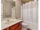Neutral bathroom with wood vanity, tub with shower, and coordinated decor at 2185 Creole Cir, Cumming, GA 30040