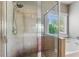 Contemporary tiled shower next to soaking tub with a window offering natural light at 2185 Creole Cir, Cumming, GA 30040