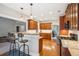Well-lit kitchen boasts wooden cabinets, granite countertops, stainless appliances, breakfast bar, and hardwood flooring at 2185 Creole Cir, Cumming, GA 30040