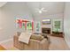 Cozy living room with a fireplace, ceiling fan, and natural light streaming through the windows at 2185 Creole Cir, Cumming, GA 30040