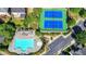 Aerial view of the community pool, tennis courts, and parking lot surrounded by lush greenery at 2425 Delamore Chase, Duluth, GA 30097