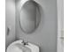 Bright bathroom featuring a white sink, modern faucet, and an oval mirror at 2425 Delamore Chase, Duluth, GA 30097